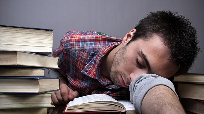 Leser / lesender Mann schläft über seiner Lektüre ein